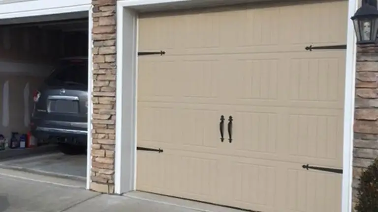 A rebuilt garage bay with a new door, stone surround and finished trim