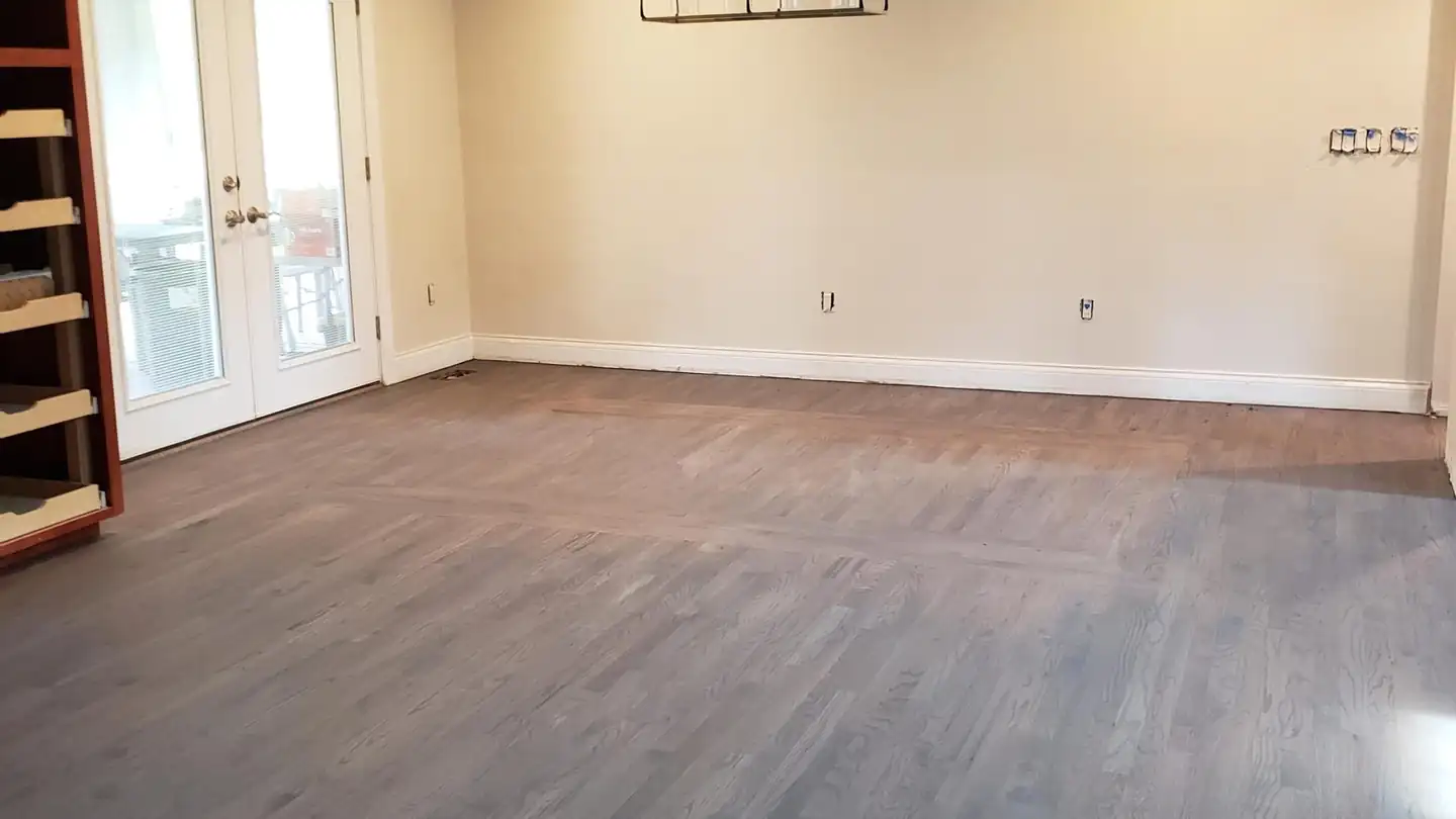A room after restoration with new wide-plank flooring and fresh paint