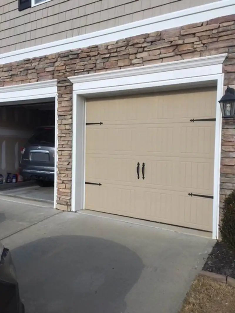 A rebuilt garage bay with a new door and stone surround