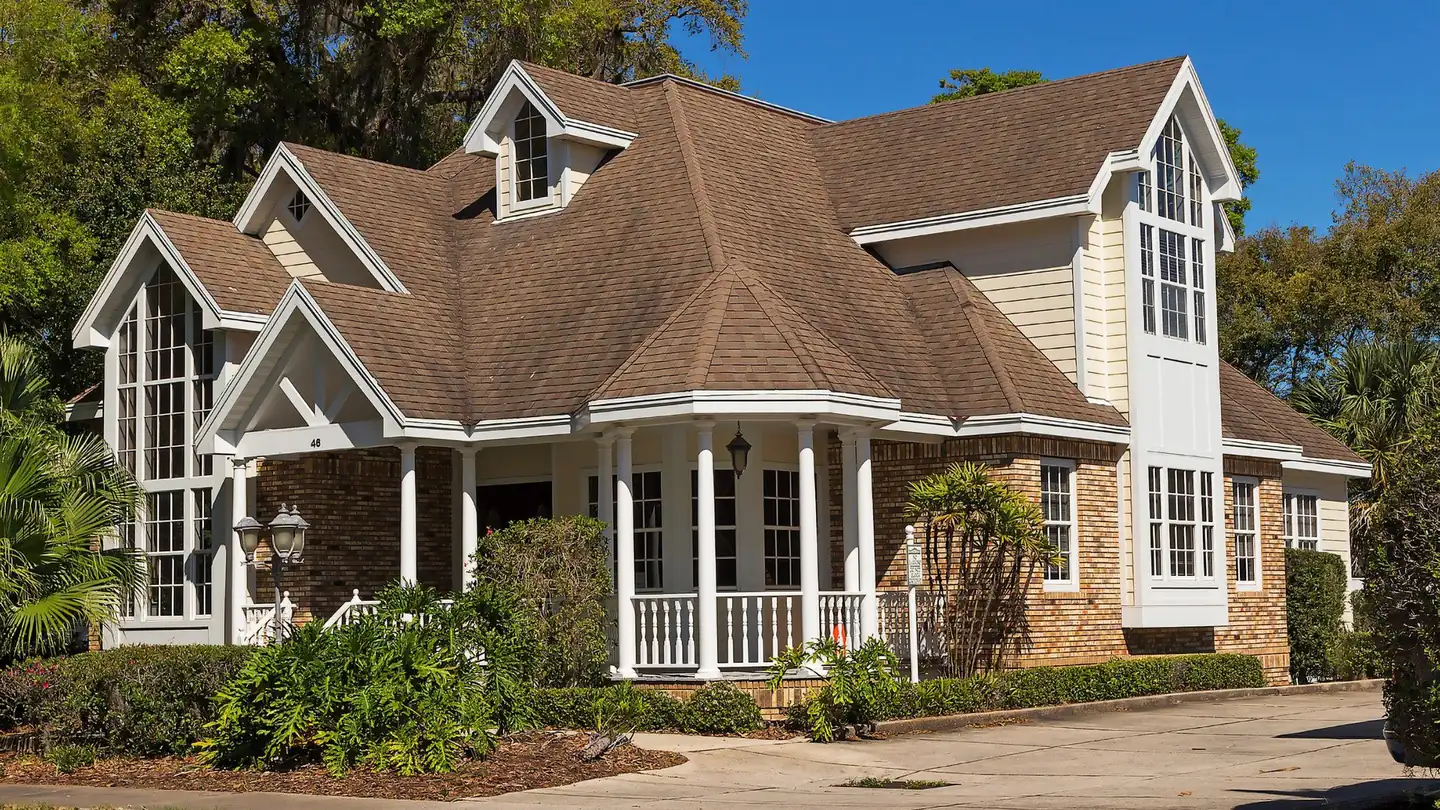 A Caromark-built home with a covered front porch, bay windows and gabled dormers