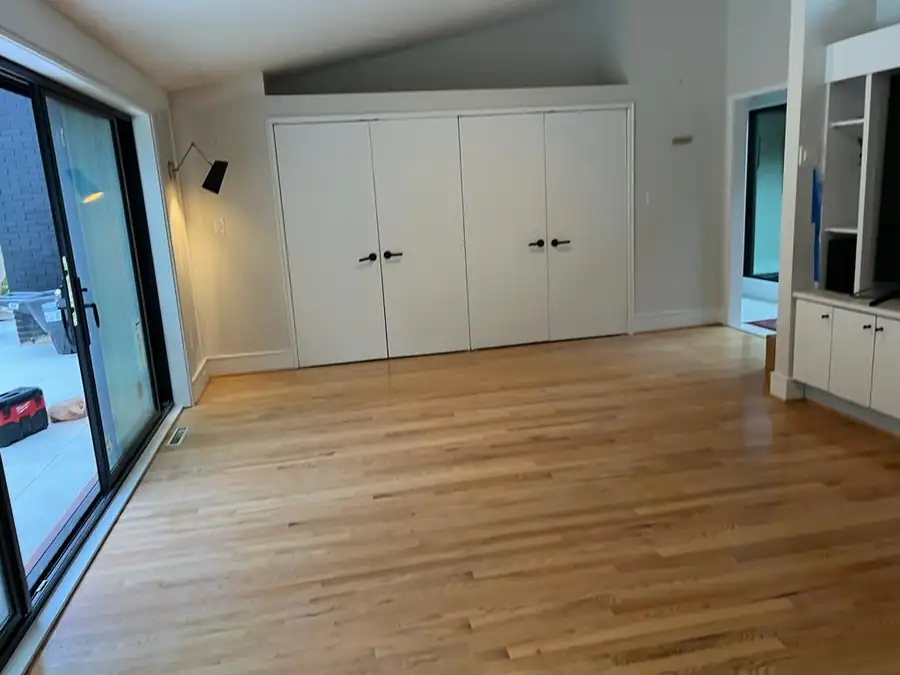 A room opening through new glass doors to a pool deck