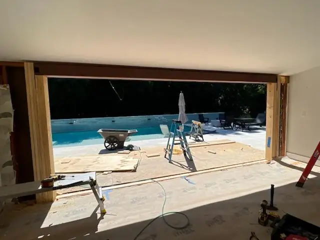 The exterior wall opened up to the framing, looking out toward the pool deck