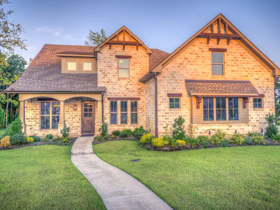Two-storey new home with brick and stone elevation and a landscaped walk