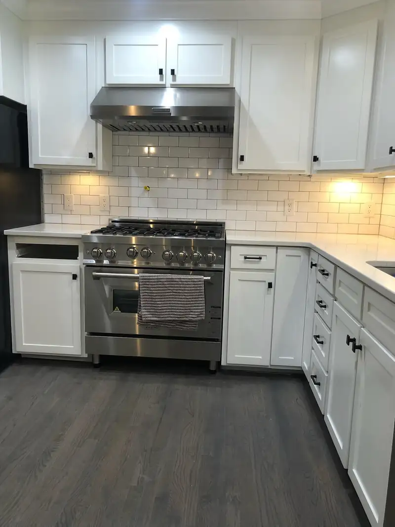 The finished kitchen with a gas range and stainless hood