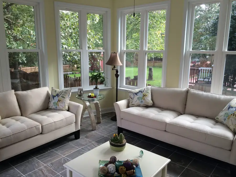 A sunroom beneath a wall of windows